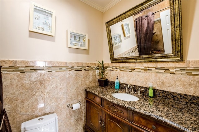 bathroom with tile walls, crown molding, vanity, and toilet