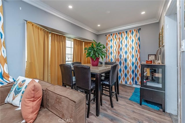 dining room with hardwood / wood-style floors and crown molding