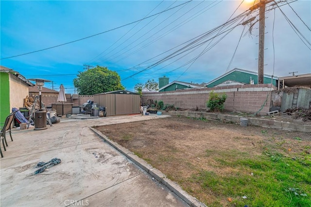 view of yard with a storage shed and a patio area