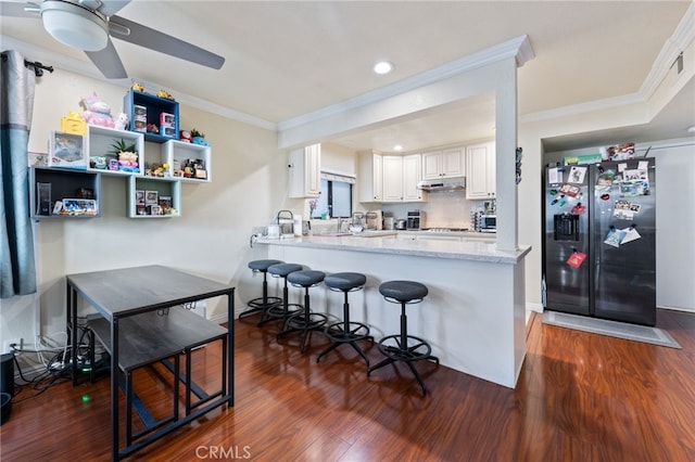 kitchen featuring white cabinets, kitchen peninsula, stainless steel fridge, and decorative backsplash