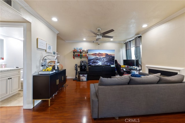 living room featuring ceiling fan, crown molding, and dark hardwood / wood-style floors