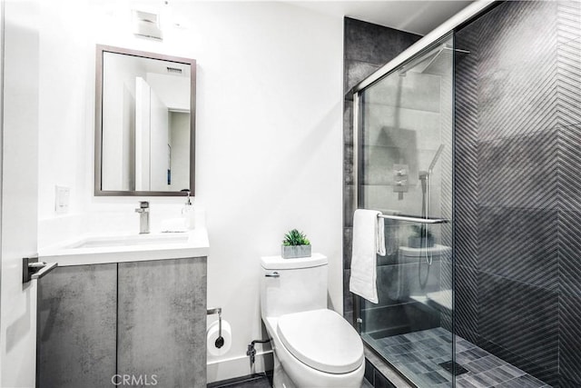 bathroom with toilet, vanity, and an enclosed shower