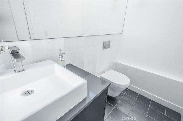 bathroom featuring toilet, vanity, tile walls, tasteful backsplash, and tile patterned floors