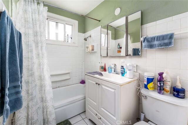 bathroom featuring toilet, shower / bath combo, tile walls, and vanity