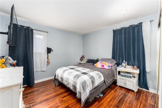 bedroom with dark wood-style flooring and baseboards