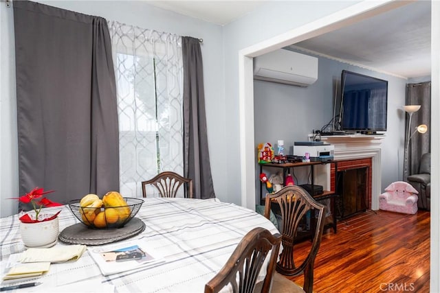 dining area with an AC wall unit, dark wood-style flooring, and a fireplace