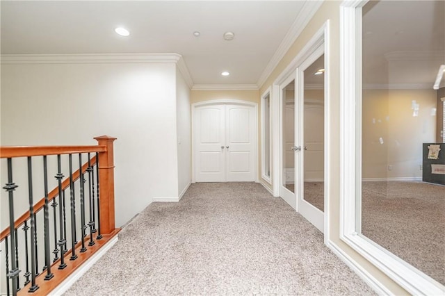 corridor with ornamental molding and light colored carpet