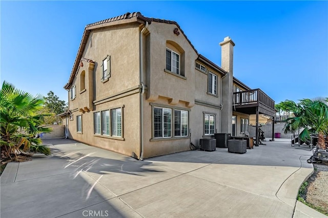 back of house featuring a balcony, a patio, and cooling unit