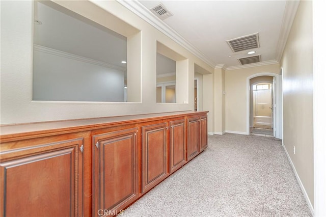 hallway with crown molding and light carpet