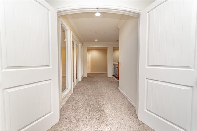 hallway featuring crown molding and light carpet