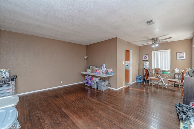 interior space with ceiling fan, a textured ceiling, and dark hardwood / wood-style flooring