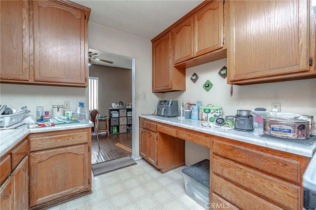 kitchen featuring built in desk and ceiling fan