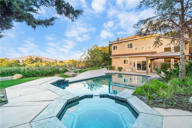 view of pool with a gazebo, a mountain view, a patio area, and an in ground hot tub