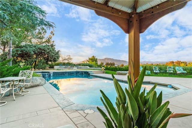 view of swimming pool with a mountain view and a patio