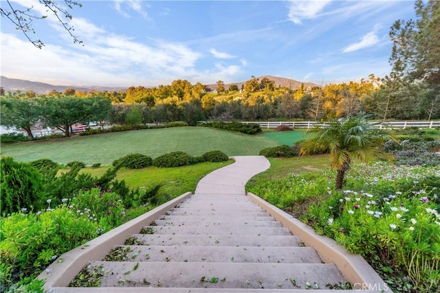 surrounding community with a mountain view and a yard