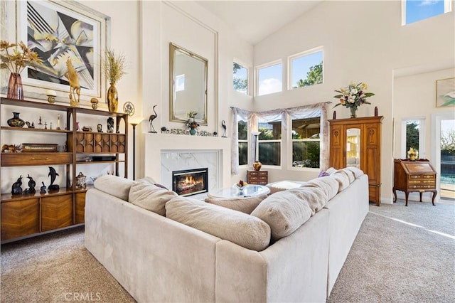 carpeted living room with a towering ceiling, a fireplace, and a wealth of natural light