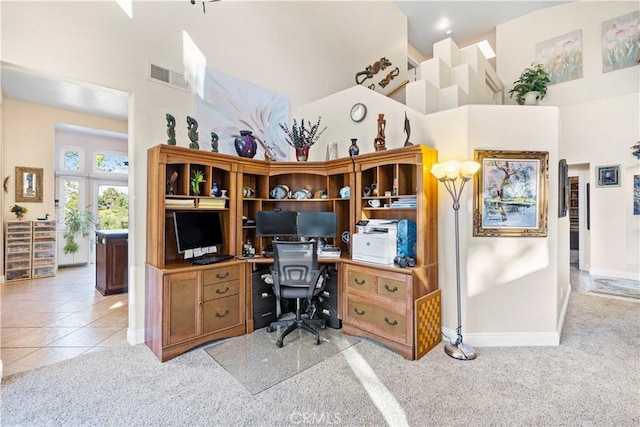 carpeted home office with a high ceiling