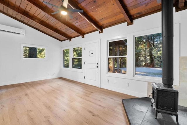 unfurnished sunroom featuring a wood stove, a wall mounted AC, vaulted ceiling with beams, ceiling fan, and wooden ceiling