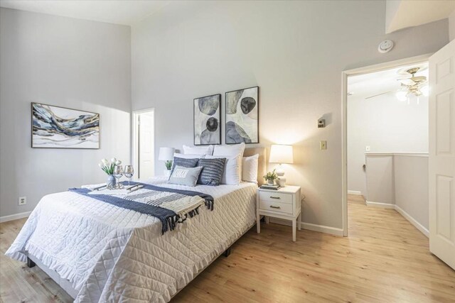 bedroom with a high ceiling and light wood-type flooring