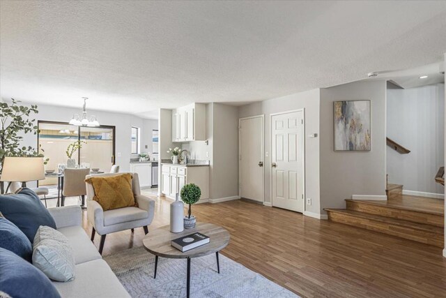 living room featuring a textured ceiling, dark wood-type flooring, and a chandelier