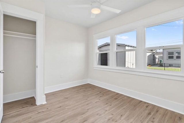 unfurnished bedroom featuring a closet, ceiling fan, and light wood-type flooring