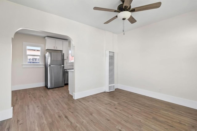 unfurnished living room with ceiling fan and light wood-type flooring