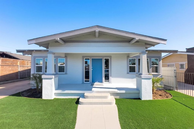 view of front of house with covered porch and a front lawn