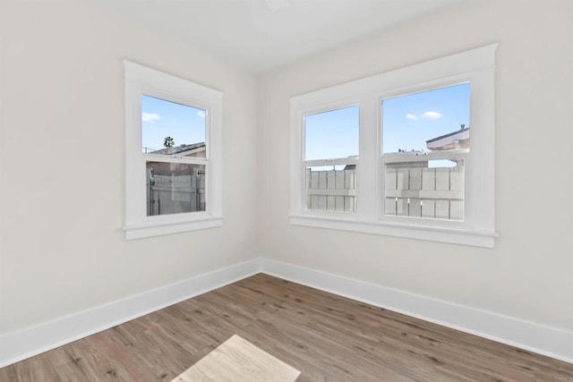 spare room with a wealth of natural light and hardwood / wood-style floors