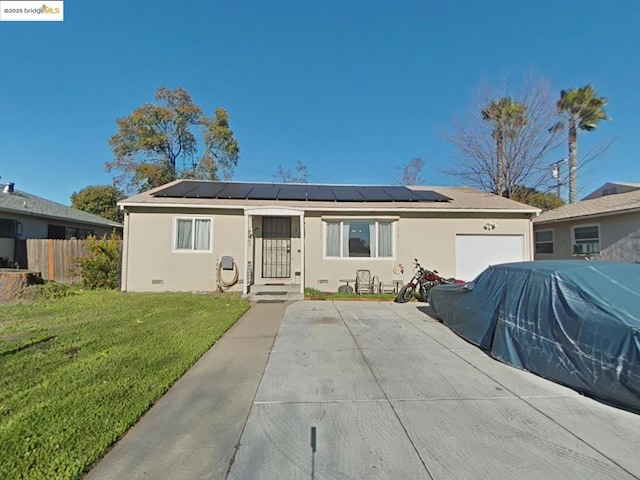 single story home with solar panels, a garage, and a front lawn