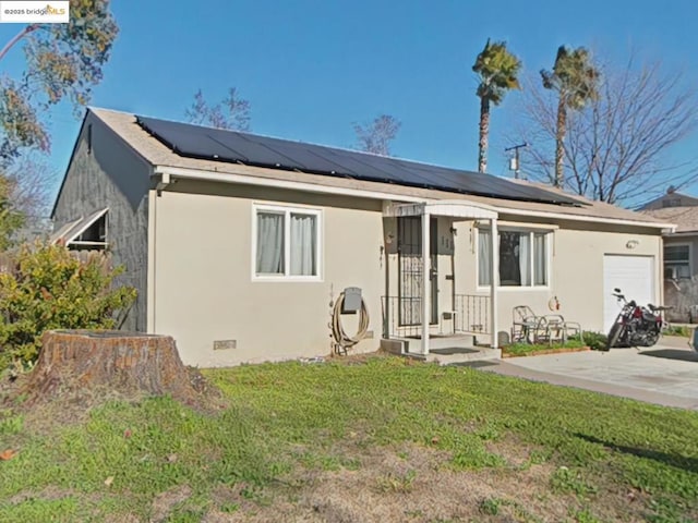 view of front of house with solar panels, a garage, and a front yard