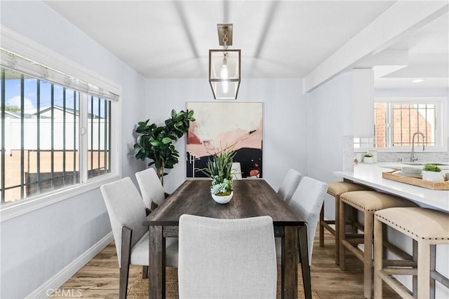 dining area featuring light wood-type flooring and sink