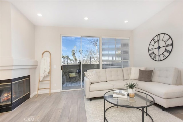 living room with a large fireplace and light hardwood / wood-style floors