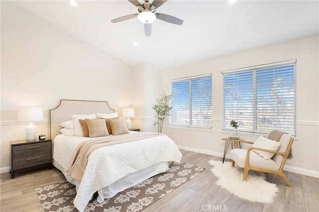 bedroom featuring ceiling fan, light hardwood / wood-style floors, and lofted ceiling