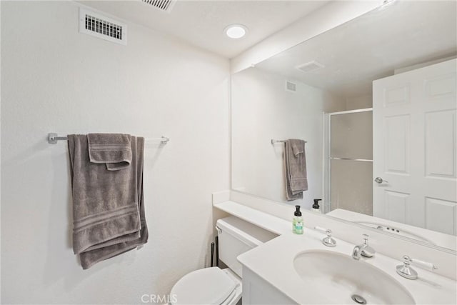 bathroom featuring toilet, a shower with door, and vanity