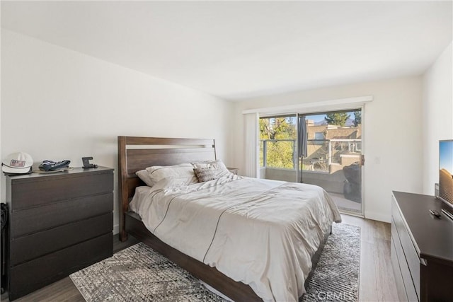 bedroom with access to outside and hardwood / wood-style flooring