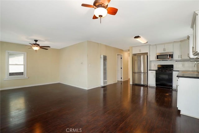 kitchen with white cabinetry, sink, stainless steel appliances, dark hardwood / wood-style floors, and backsplash