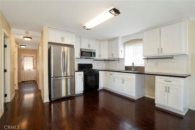 kitchen featuring white cabinets, appliances with stainless steel finishes, decorative backsplash, and sink