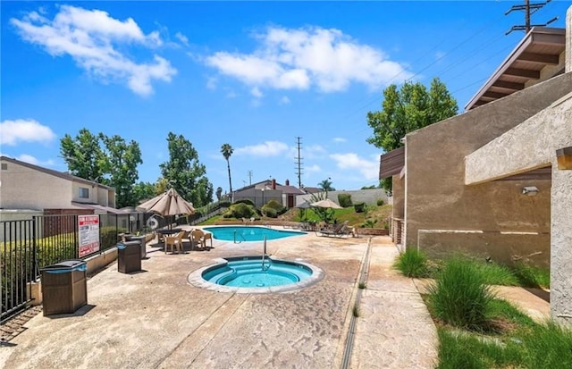 view of swimming pool featuring a patio area and a hot tub