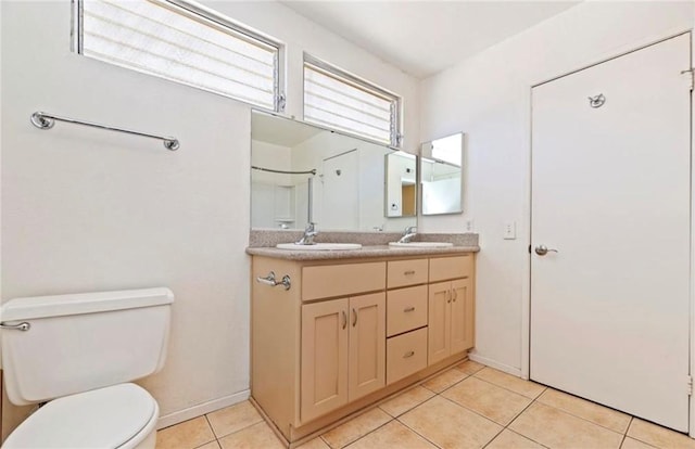 bathroom with toilet, vanity, and tile patterned flooring