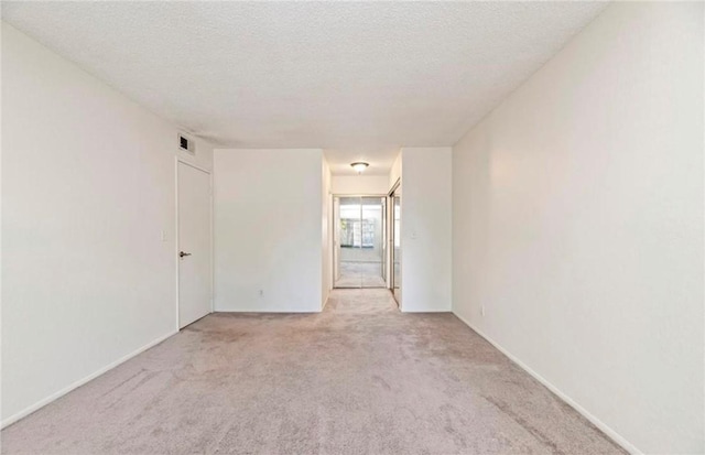 carpeted spare room with a textured ceiling