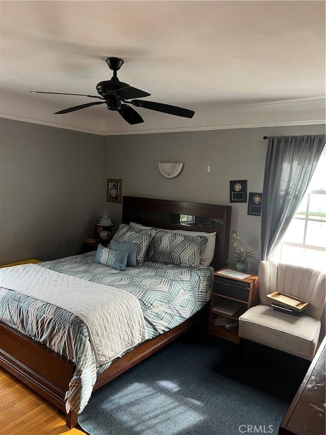 bedroom featuring ceiling fan, wood-type flooring, and crown molding