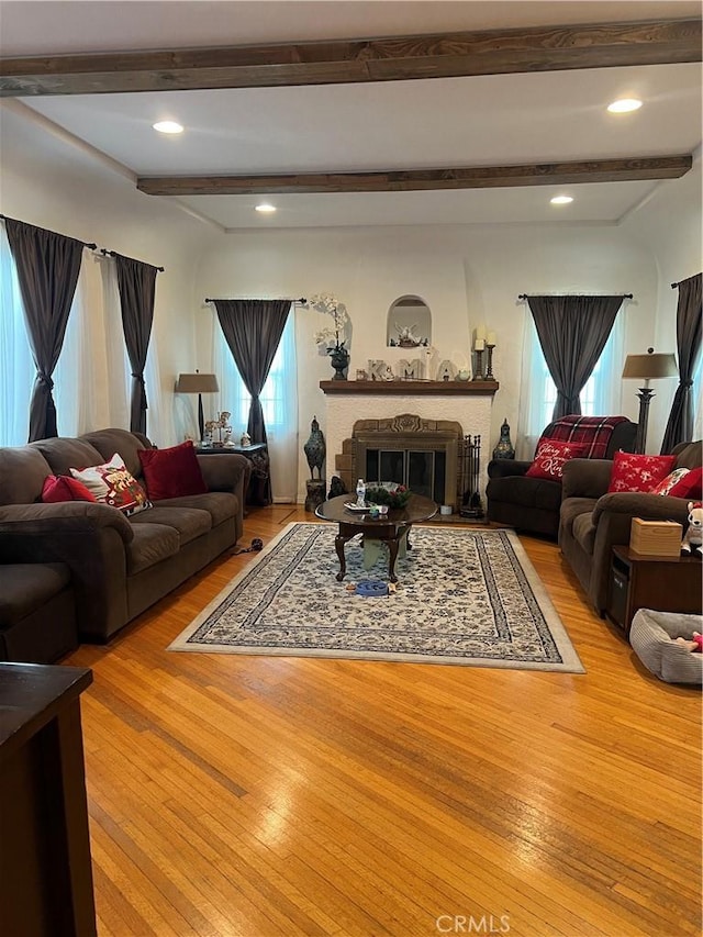 living room with light hardwood / wood-style flooring and beam ceiling