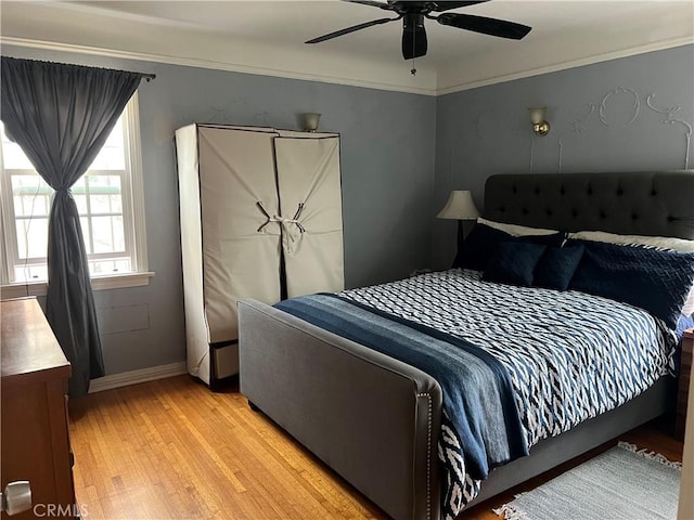 bedroom featuring light wood-type flooring, ceiling fan, and crown molding