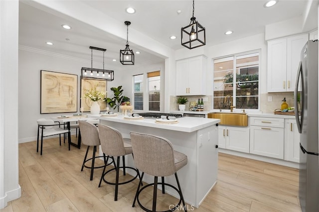 kitchen featuring a kitchen island, sink, and white cabinetry