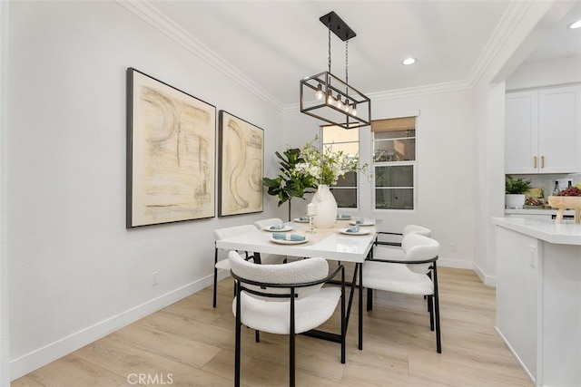 dining space featuring a notable chandelier, light wood-type flooring, and crown molding