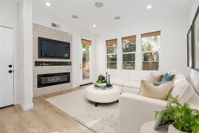 living room with light hardwood / wood-style flooring and a fireplace