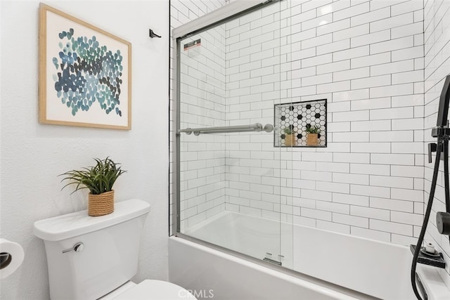 bathroom with toilet and combined bath / shower with glass door