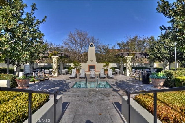 view of swimming pool featuring an outdoor fireplace and a patio area