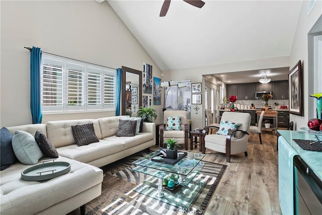 living room featuring light wood-type flooring, high vaulted ceiling, and ceiling fan