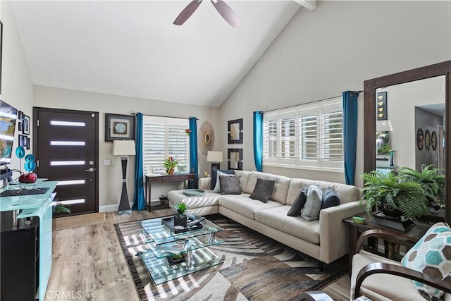 living room featuring lofted ceiling with beams, light hardwood / wood-style flooring, and ceiling fan